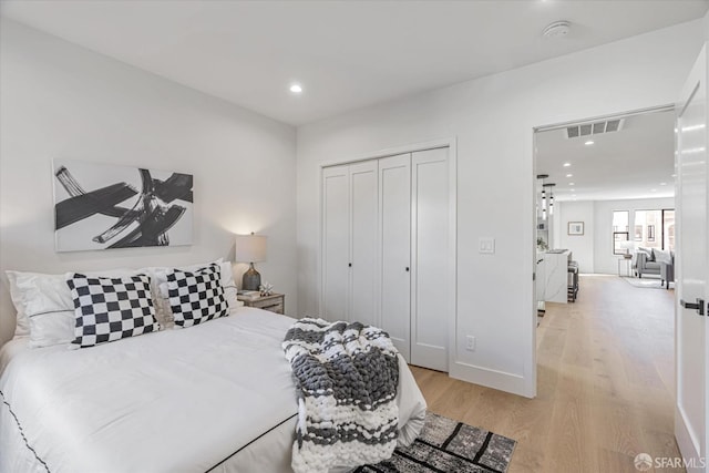 bedroom with light wood-type flooring and a closet