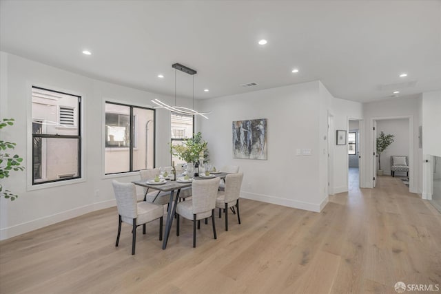 dining space with an inviting chandelier and light hardwood / wood-style floors