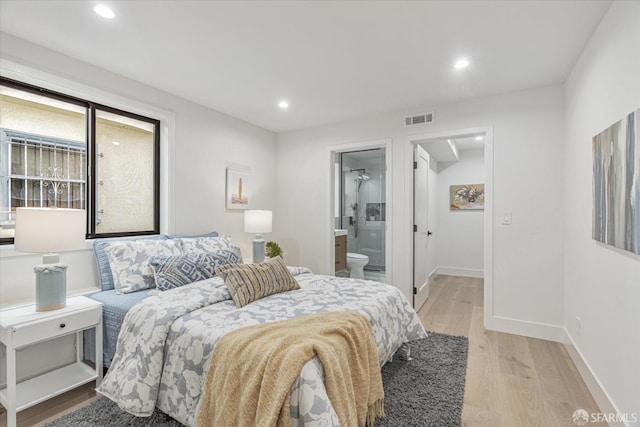 bedroom featuring ensuite bath and light hardwood / wood-style flooring