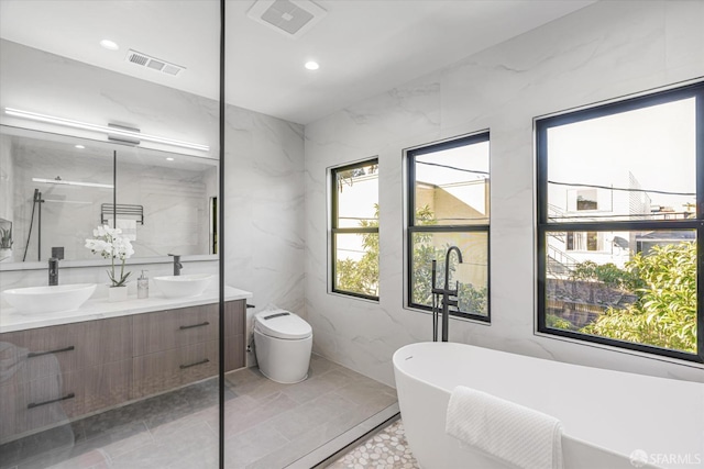 bathroom featuring vanity, a bathing tub, tile walls, and toilet