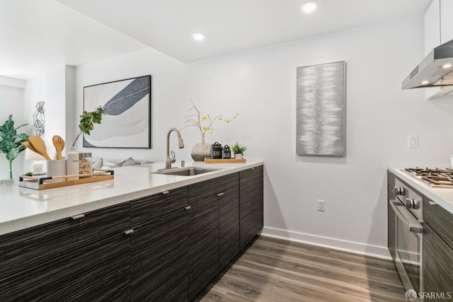 1688 Pine St Unit E709, San Francisco, CA 94109 - kitchen with a sink, wall chimney range hood, light countertops, dark wood finished floors, and modern cabinets