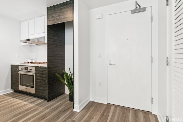1688 Pine St Unit E709, San Francisco, CA 94109 - kitchen featuring stainless steel appliances, under cabinet range hood, light wood-type flooring, baseboards, and modern cabinets