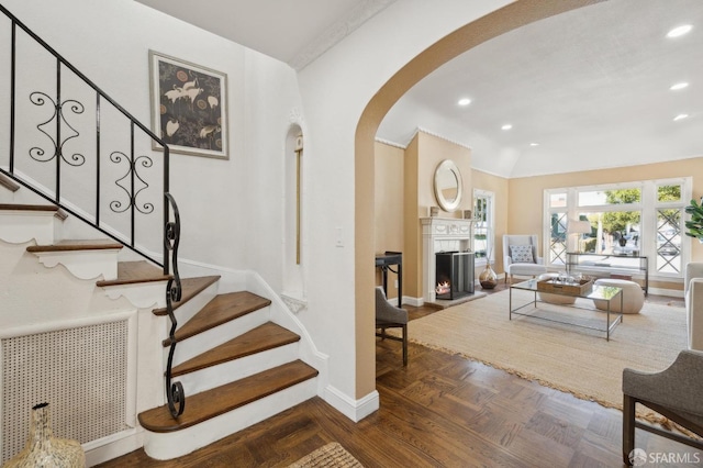 staircase with lofted ceiling and parquet floors