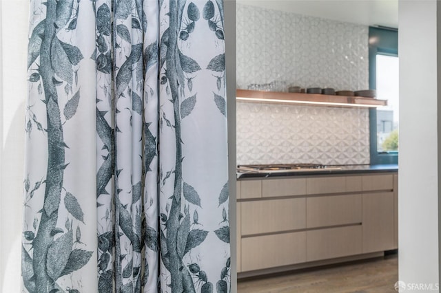 bathroom with wood-type flooring, a shower with curtain, tasteful backsplash, and vanity