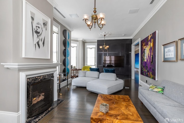 living room with ornamental molding, a chandelier, dark wood-type flooring, and a fireplace