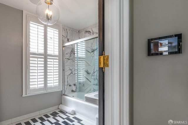 bathroom with bath / shower combo with glass door, tile patterned floors, toilet, and a healthy amount of sunlight