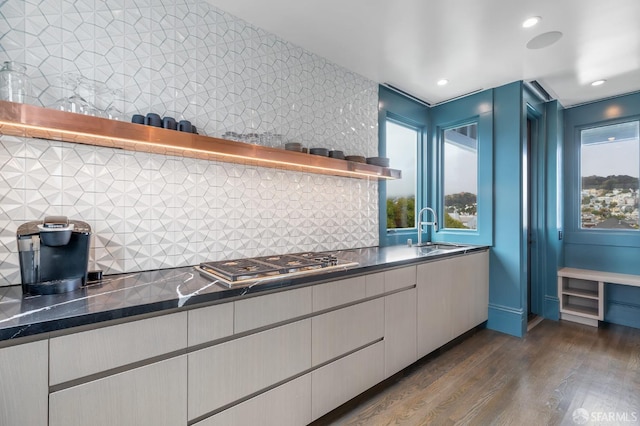 kitchen with stainless steel gas stovetop, sink, dark wood-type flooring, and tasteful backsplash