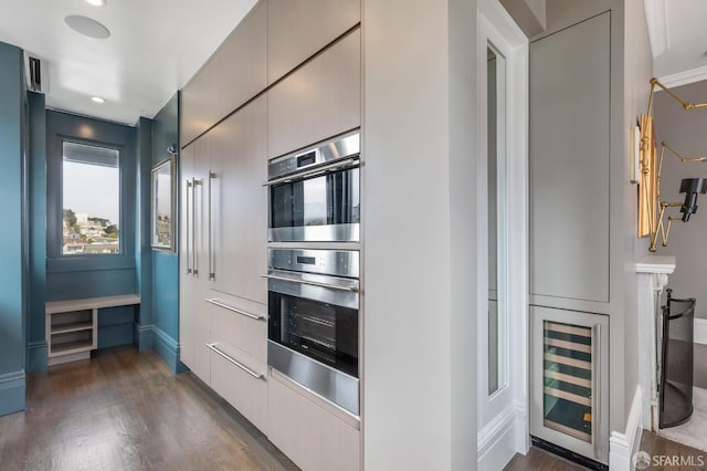 kitchen with wine cooler, stainless steel double oven, and dark hardwood / wood-style flooring