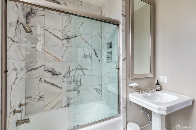 bathroom featuring shower / bath combination with glass door and toilet