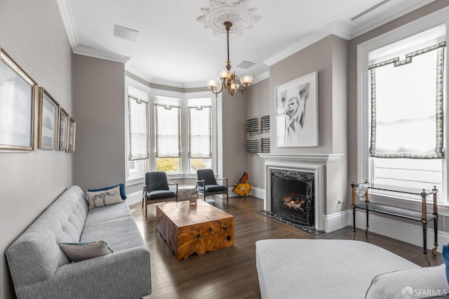 living room featuring a notable chandelier, ornamental molding, dark hardwood / wood-style floors, and a fireplace