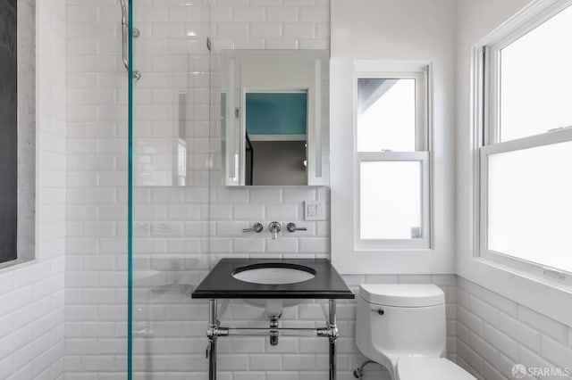 bathroom featuring tile walls, sink, and toilet