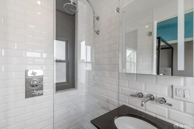 bathroom with tiled shower and vanity