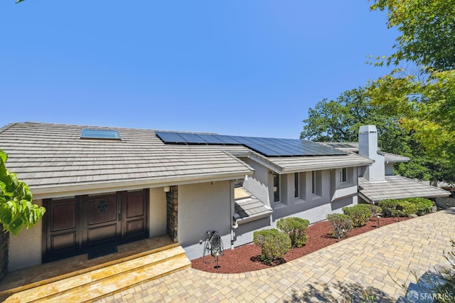 12553 Parker Ranch Ct, Saratoga, CA 95070 - view of front facade featuring stucco siding, a chimney, and roof mounted solar panels