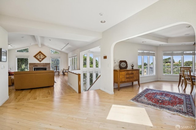 12553 Parker Ranch Ct, Saratoga, CA 95070 - living room featuring arched walkways, hardwood / wood-style flooring, a fireplace, and baseboards