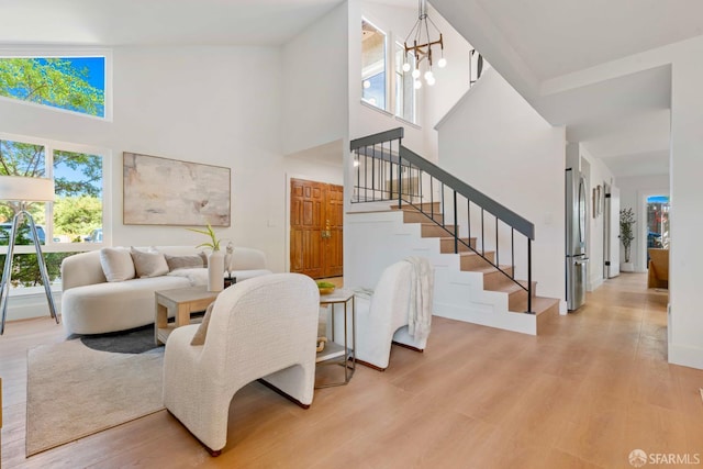 1945 Las Encinas Ct, Los Gatos, CA 95032 - living room with a high ceiling, light wood-style flooring, a chandelier, and stairs