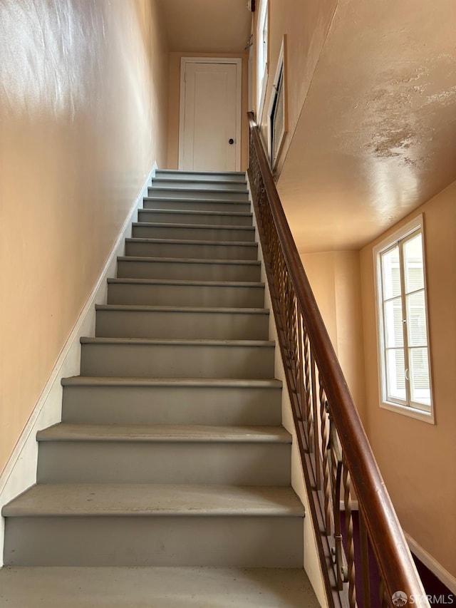 staircase featuring baseboards