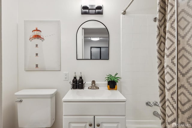 full bathroom featuring vanity, tiled shower / bath combo, and toilet