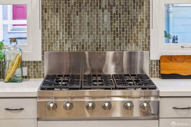 details featuring tasteful backsplash and stainless steel gas cooktop