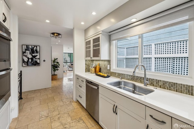 kitchen with white cabinetry, appliances with stainless steel finishes, sink, and tasteful backsplash