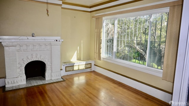 unfurnished living room featuring hardwood / wood-style flooring and ornamental molding