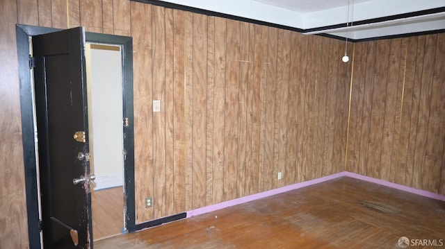 spare room featuring dark hardwood / wood-style floors and wood walls