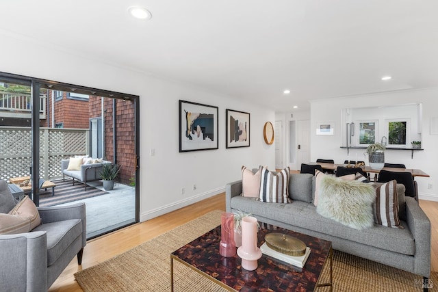 living area with baseboards, recessed lighting, and light wood-style flooring