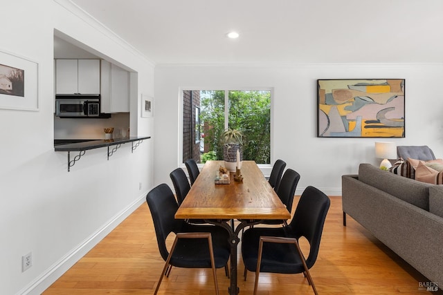 dining area with crown molding, recessed lighting, baseboards, and light wood-type flooring
