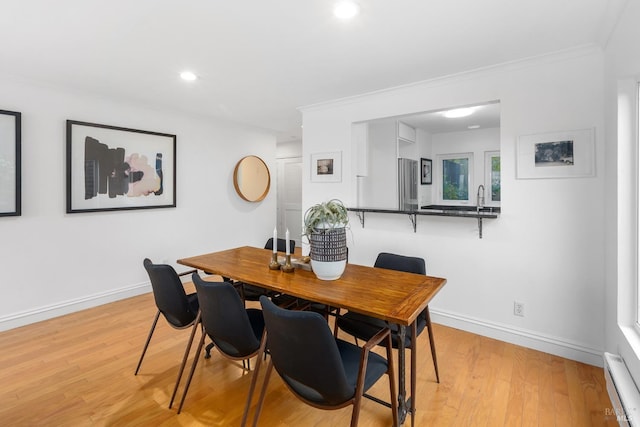 dining area featuring recessed lighting, light wood-style flooring, baseboard heating, ornamental molding, and baseboards