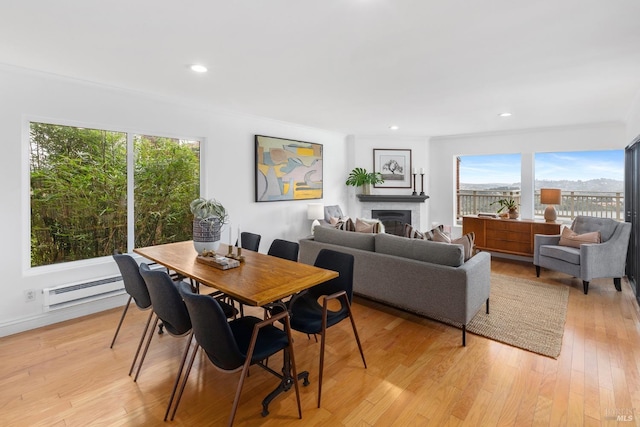 dining room with baseboard heating, recessed lighting, light wood finished floors, and a fireplace