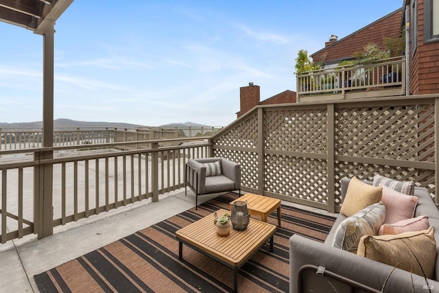 deck featuring outdoor lounge area and a mountain view