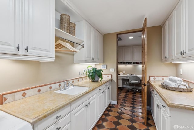 kitchen with white cabinets, light countertops, and a sink