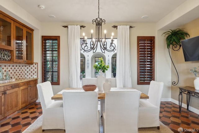 dining space featuring a notable chandelier and baseboards