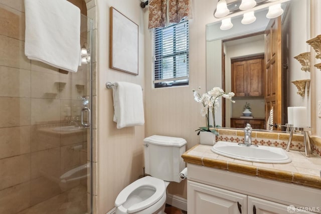 bathroom featuring a stall shower, toilet, and vanity