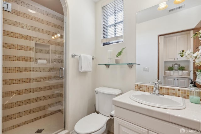 full bath featuring vanity, a shower stall, tasteful backsplash, and visible vents