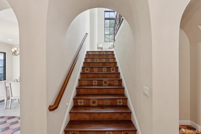 stairs with arched walkways and baseboards