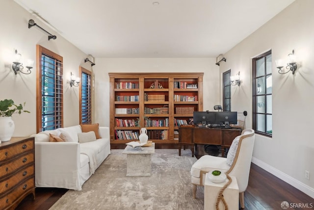 living area with baseboards and wood finished floors