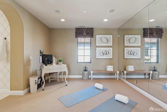 exercise area featuring arched walkways, recessed lighting, baseboards, and carpet