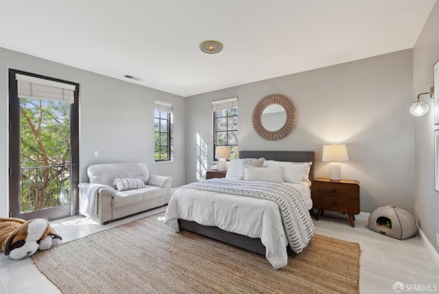 bedroom featuring light tile patterned flooring, visible vents, baseboards, and access to outside