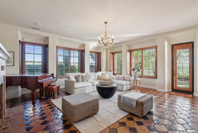 living room with a fireplace, baseboards, visible vents, and a chandelier