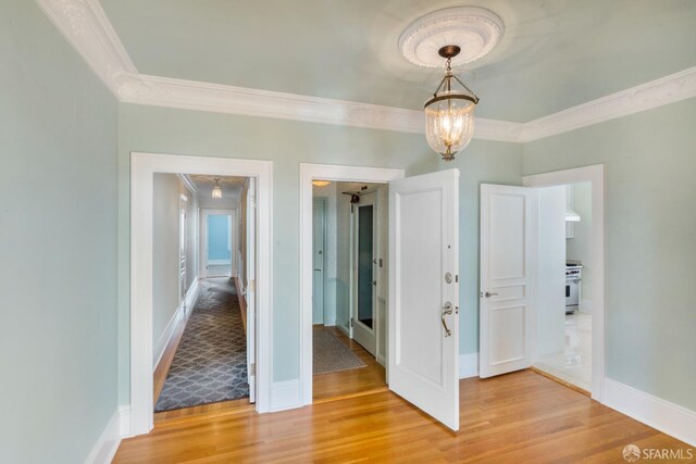 interior space featuring ornamental molding, a chandelier, and hardwood / wood-style flooring