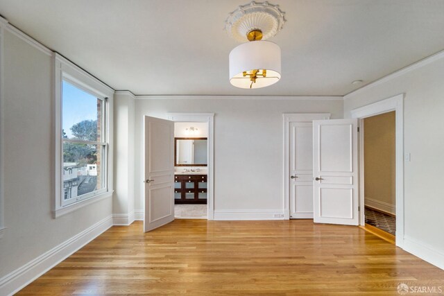 spare room with crown molding and light hardwood / wood-style floors