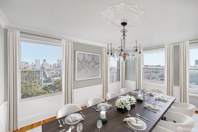 dining space featuring an inviting chandelier, hardwood / wood-style flooring, and crown molding