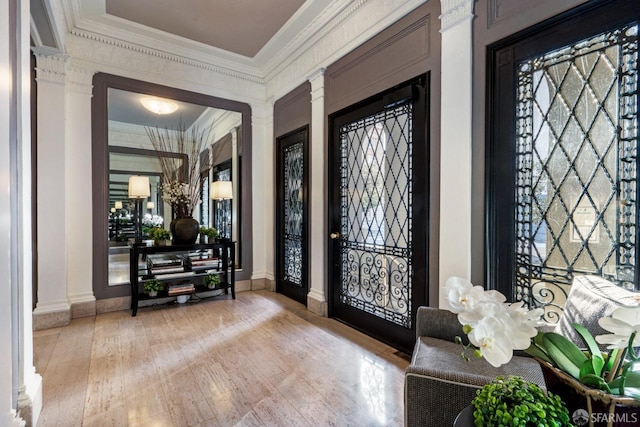 foyer with ornamental molding and light hardwood / wood-style floors