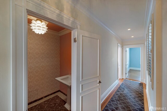 hallway featuring ornamental molding and dark wood-type flooring