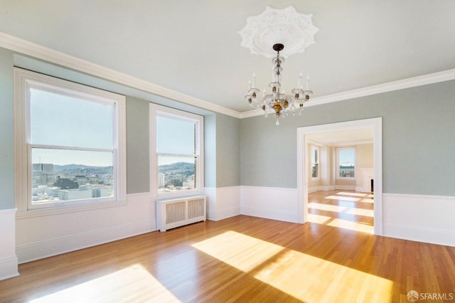 1800 Gough St Unit 7, San Francisco, CA 94109 - unfurnished room featuring radiator, a chandelier, wood finished floors, crown molding, and a wainscoted wall