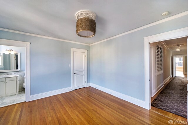 empty room featuring light wood-type flooring and crown molding