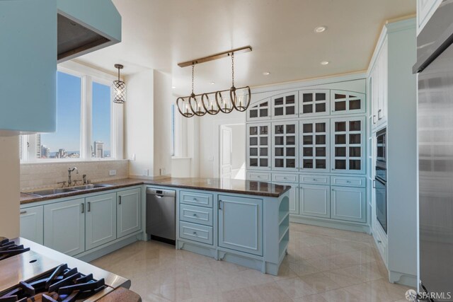 kitchen featuring pendant lighting, kitchen peninsula, appliances with stainless steel finishes, a notable chandelier, and decorative backsplash