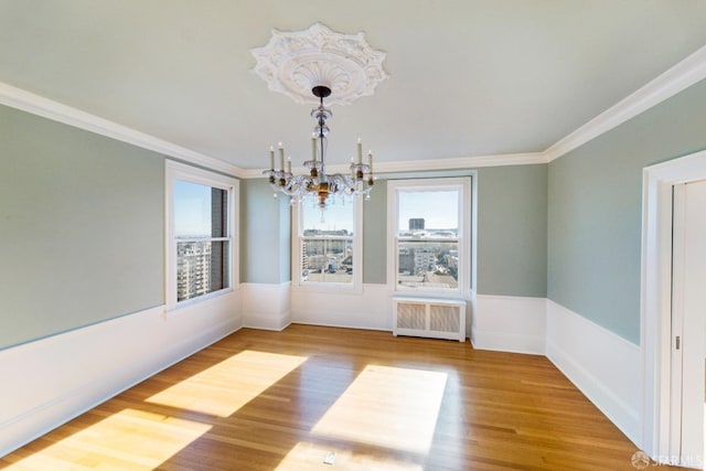 1800 Gough St Unit 7, San Francisco, CA 94109 - unfurnished dining area featuring a chandelier, radiator, ornamental molding, and wood finished floors