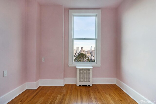 empty room with radiator and light hardwood / wood-style flooring