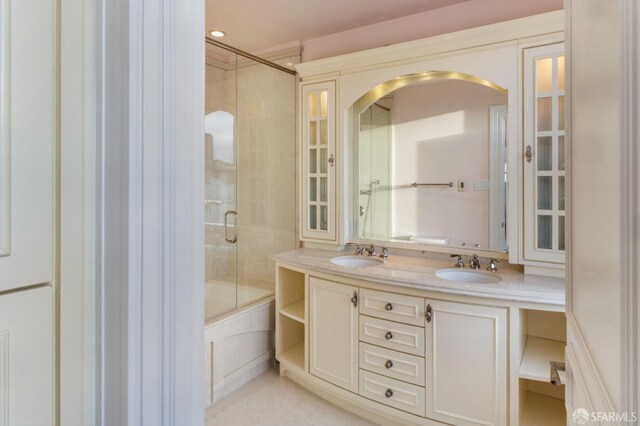 bathroom featuring shower / bath combination with glass door and vanity